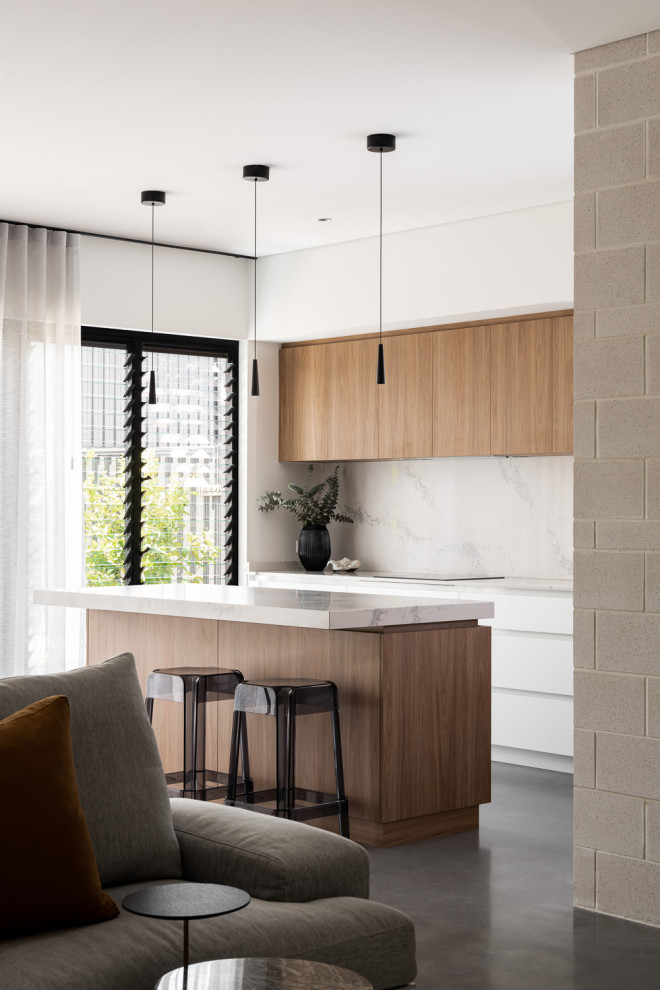 Inspiration for a medium sized retro galley open plan kitchen in Perth with flat-panel cabinets, medium wood cabinets, engineered stone countertops, marble splashback, concrete flooring and an island.