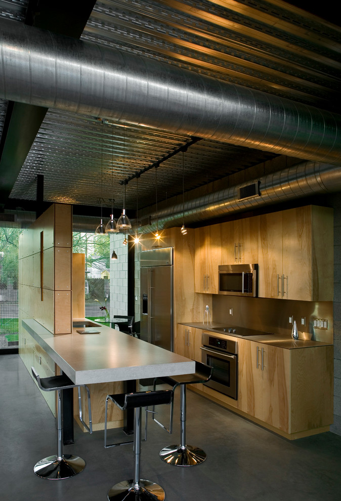 Idéer för att renovera ett mellanstort funkis kök, med en undermonterad diskho, släta luckor, skåp i ljust trä, bänkskiva i betong, stänkskydd med metallisk yta, stänkskydd i metallkakel, rostfria vitvaror, betonggolv och en köksö