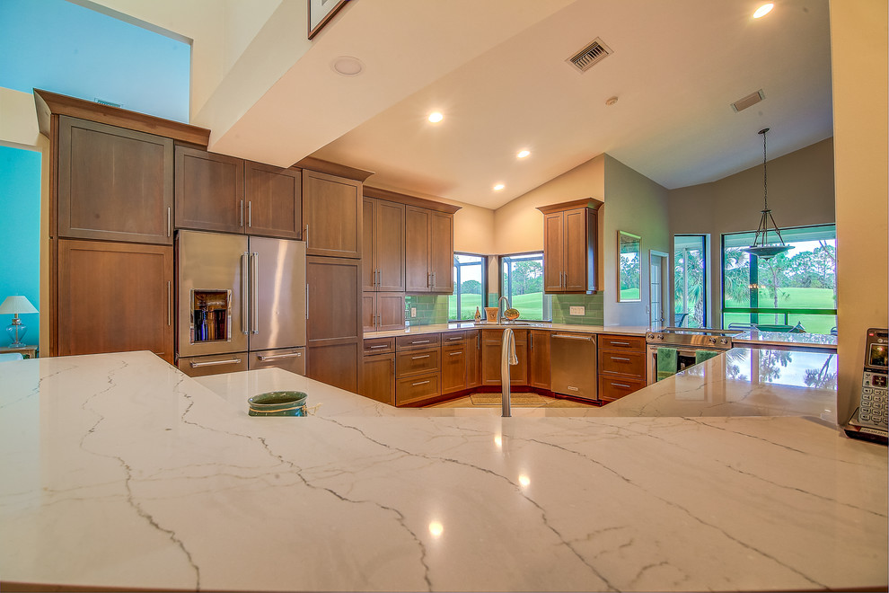 Large transitional l-shaped porcelain tile and gray floor eat-in kitchen photo in Miami with a single-bowl sink, shaker cabinets, gray cabinets, glass countertops, blue backsplash, subway tile backsplash and stainless steel appliances