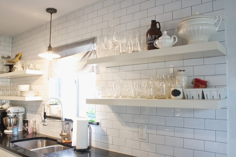 Foto på ett mellanstort lantligt kök, med en dubbel diskho, öppna hyllor, vita skåp, granitbänkskiva, vitt stänkskydd, stänkskydd i tunnelbanekakel, rostfria vitvaror och mörkt trägolv