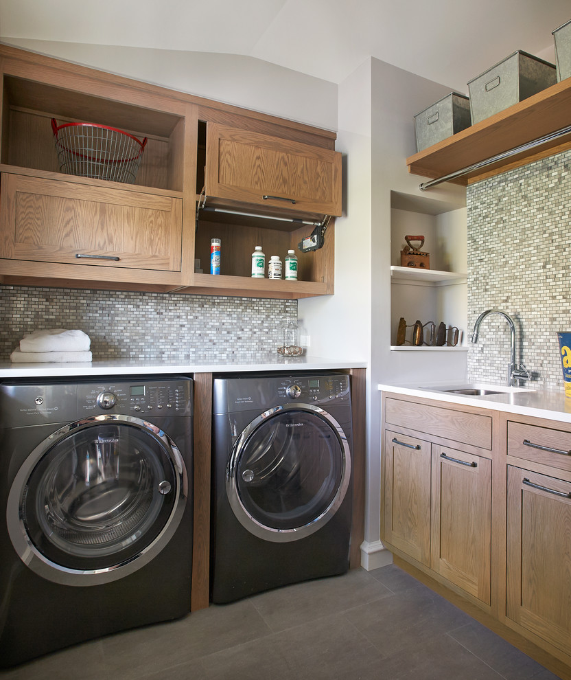 Large farmhouse l-shaped dark wood floor laundry room photo in New York with an undermount sink, shaker cabinets, gray cabinets, quartzite countertops, gray backsplash and stone slab backsplash