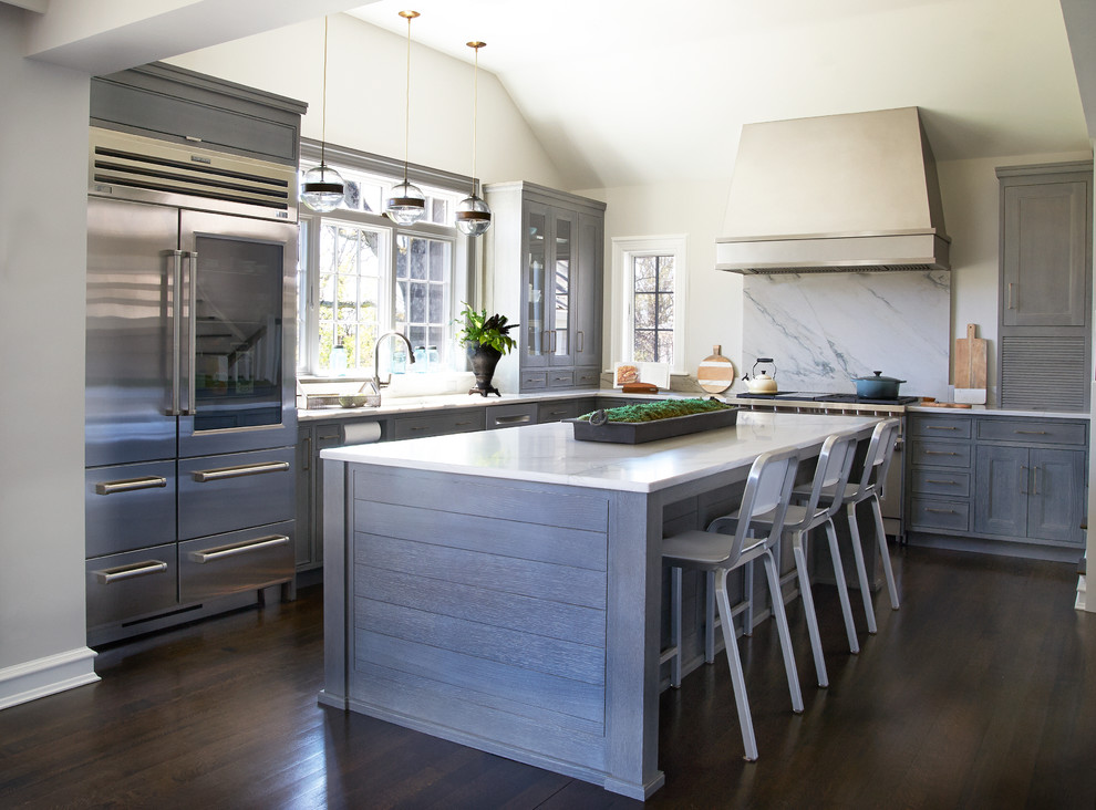 Inspiration for a large transitional l-shaped dark wood floor eat-in kitchen remodel in New York with an undermount sink, gray cabinets, quartzite countertops, gray backsplash, stone slab backsplash, stainless steel appliances, an island and shaker cabinets