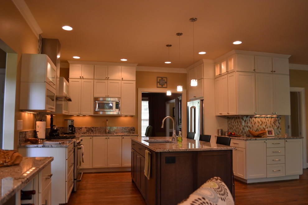 Ejemplo de cocina minimalista con fregadero bajoencimera, puertas de armario blancas, electrodomésticos de acero inoxidable, suelo de madera clara y una isla