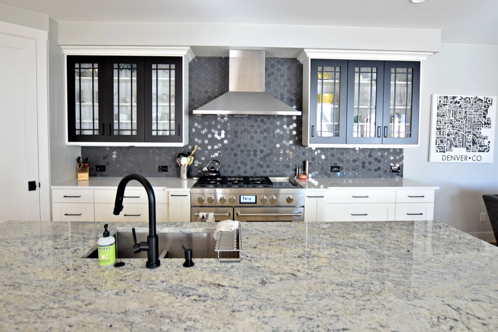 Large transitional l-shaped light wood floor open concept kitchen photo in Denver with an undermount sink, shaker cabinets, white cabinets, black backsplash, stainless steel appliances, an island, granite countertops and mosaic tile backsplash