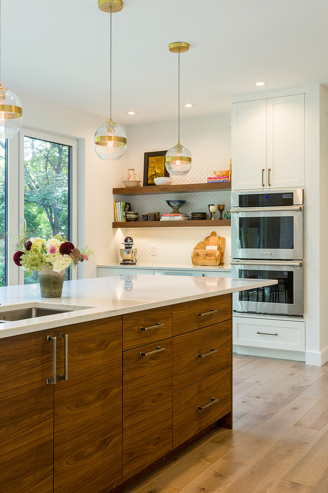 Foto di una grande cucina moderna con lavello sottopiano, ante lisce, ante in legno scuro, top in quarzo composito, paraspruzzi bianco, elettrodomestici in acciaio inossidabile, parquet chiaro, 2 o più isole e pavimento marrone