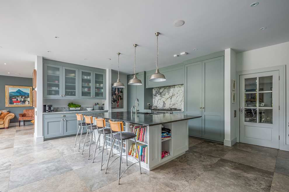 Modern inredning av ett kök med öppen planlösning, med en dubbel diskho, skåp i shakerstil, flerfärgad stänkskydd, rostfria vitvaror, en köksö och grått golv