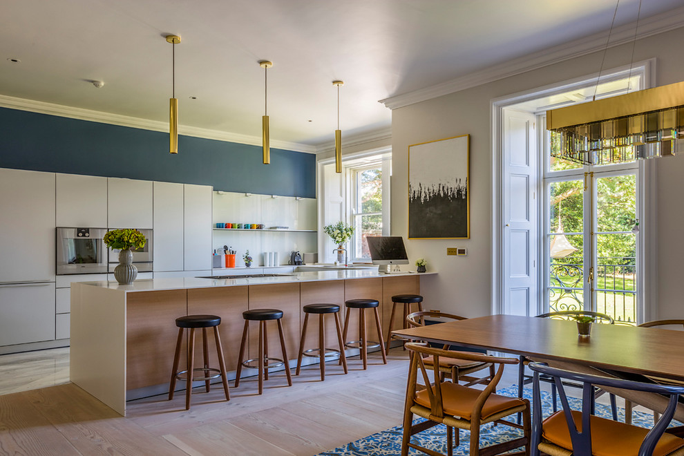 Zweizeilige Klassische Wohnküche mit flächenbündigen Schrankfronten, weißen Schränken, hellem Holzboden und Halbinsel in Dublin