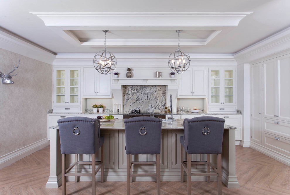 Large elegant l-shaped porcelain tile enclosed kitchen photo in Dublin with an undermount sink, louvered cabinets, beige cabinets, granite countertops, multicolored backsplash, stone slab backsplash, stainless steel appliances and an island
