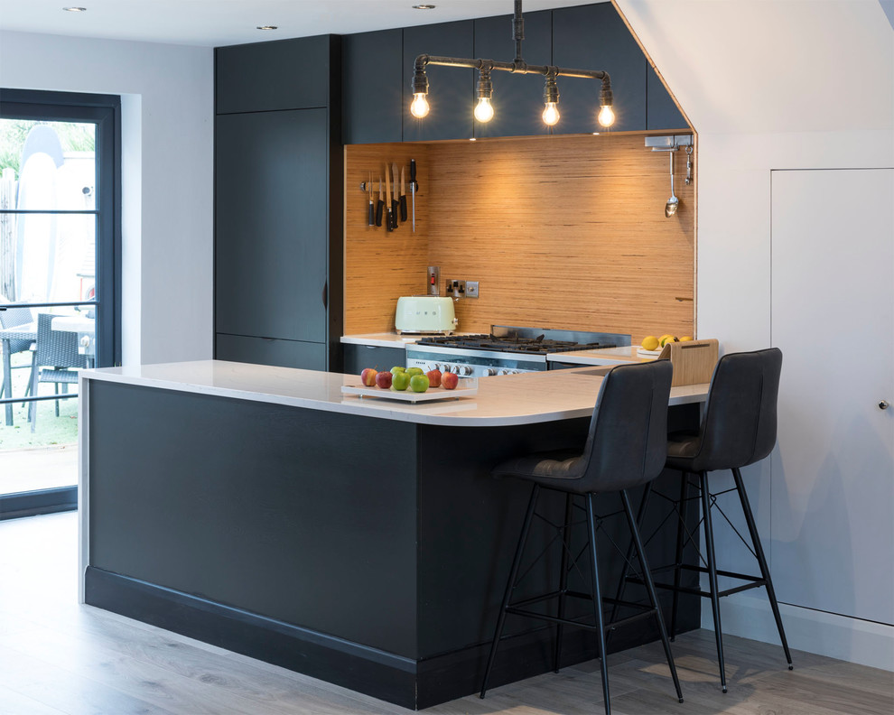 Moderne Küche in U-Form mit flächenbündigen Schrankfronten, schwarzen Schränken, Küchenrückwand in Beige, Halbinsel, grauem Boden und weißer Arbeitsplatte in Dublin