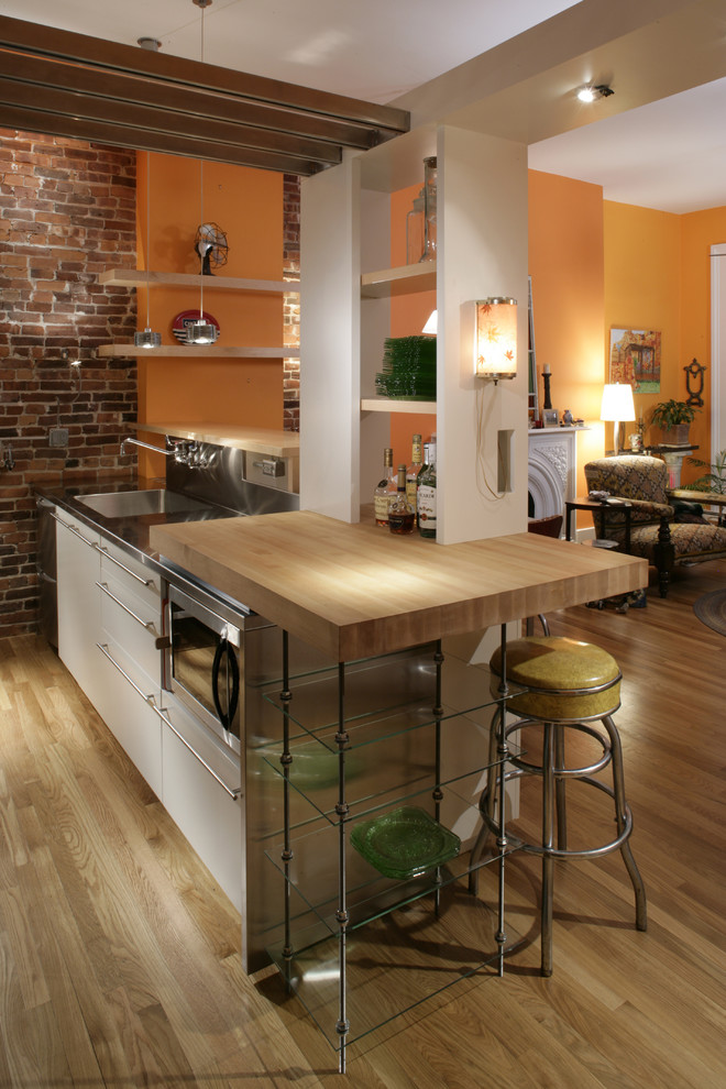 Idéer för att renovera ett funkis kök med öppen planlösning, med en integrerad diskho, släta luckor, skåp i rostfritt stål, bänkskiva i rostfritt stål och rostfria vitvaror