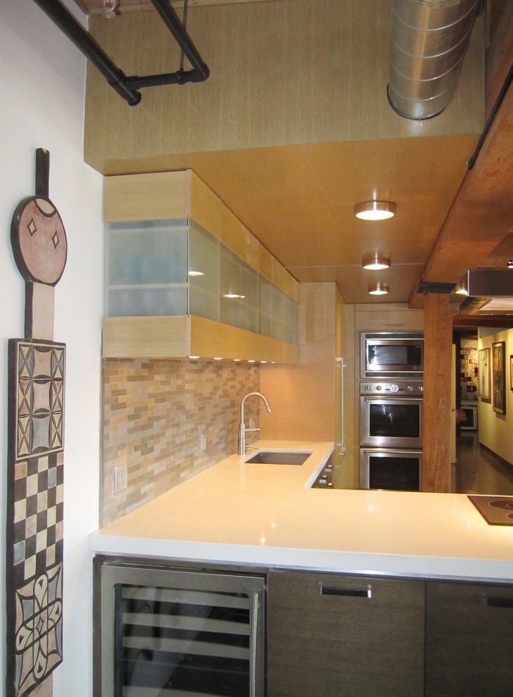 Example of a mid-sized trendy l-shaped concrete floor eat-in kitchen design in Other with an undermount sink, flat-panel cabinets, medium tone wood cabinets, quartz countertops, metallic backsplash, metal backsplash, paneled appliances and a peninsula