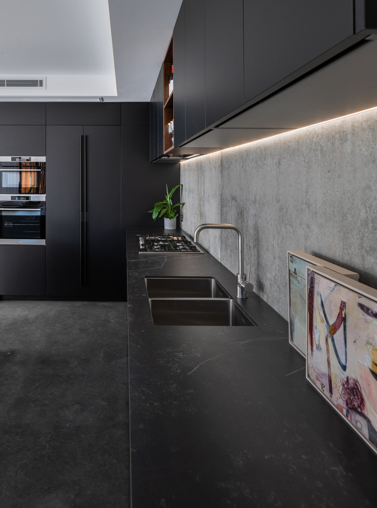 Große Moderne Küche in L-Form mit Vorratsschrank, Unterbauwaschbecken, schwarzen Schränken, Arbeitsplatte aus Fliesen, Küchenrückwand in Grau, Betonboden, Kücheninsel, grauem Boden und schwarzer Arbeitsplatte in Perth
