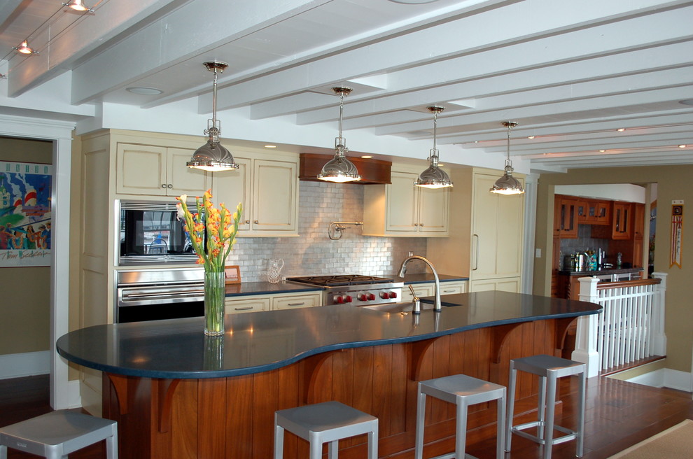 グランドラピッズにある中くらいなトランジショナルスタイルのおしゃれなキッチン (アンダーカウンターシンク、インセット扉のキャビネット、ベージュのキャビネット、メタリックのキッチンパネル、サブウェイタイルのキッチンパネル、シルバーの調理設備、茶色い床、緑のキッチンカウンター) の写真