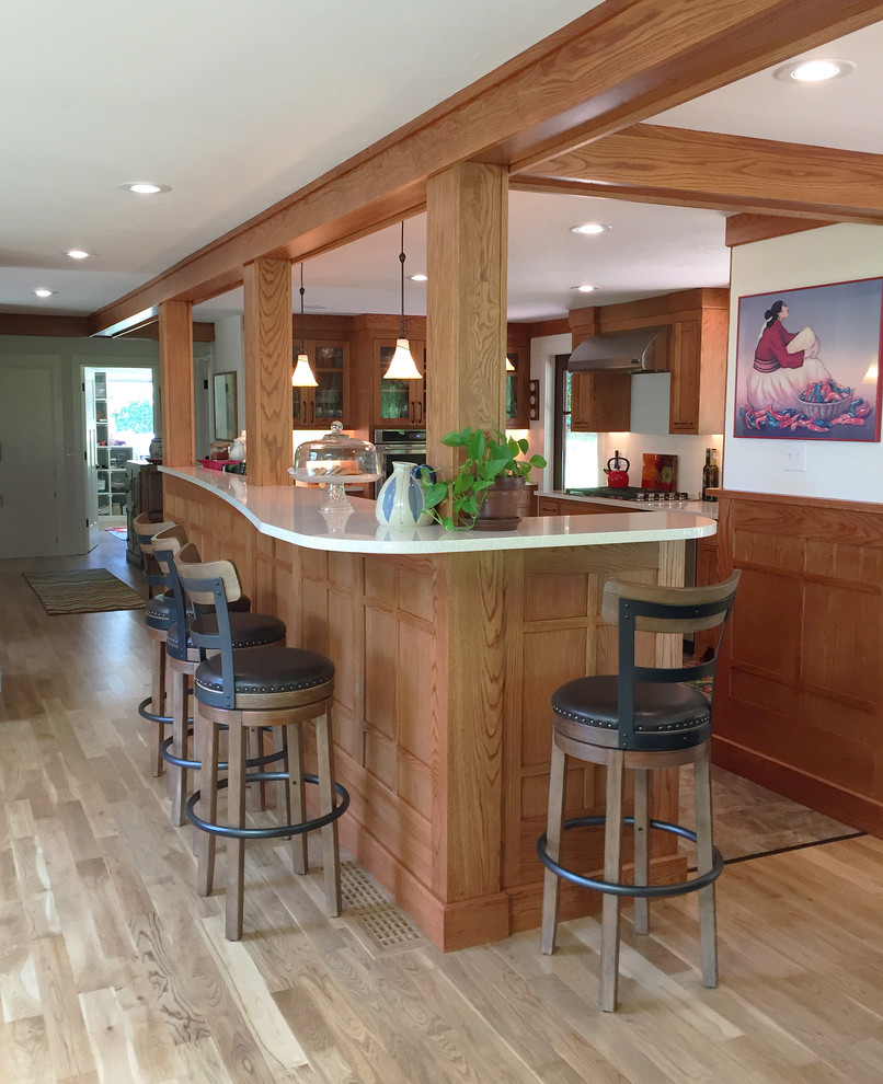 Large galley laminate floor and beige floor eat-in kitchen photo in Other with an undermount sink, shaker cabinets, medium tone wood cabinets, quartz countertops, white backsplash, ceramic backsplash, stainless steel appliances and an island