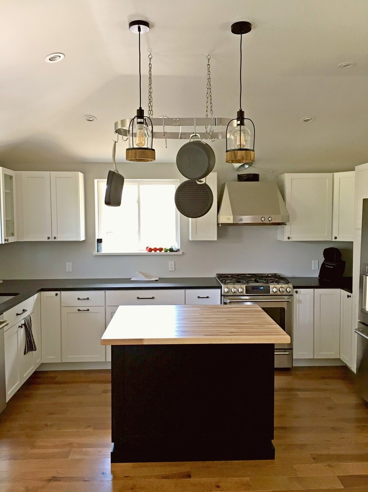 Eat-in kitchen - transitional u-shaped eat-in kitchen idea in Denver with an undermount sink, recessed-panel cabinets, white cabinets, white backsplash, stainless steel appliances and an island