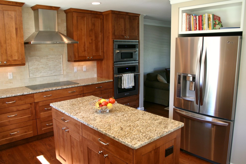 Eat-in kitchen - transitional l-shaped medium tone wood floor eat-in kitchen idea in Denver with an undermount sink, recessed-panel cabinets, medium tone wood cabinets, granite countertops, beige backsplash, ceramic backsplash, stainless steel appliances and an island