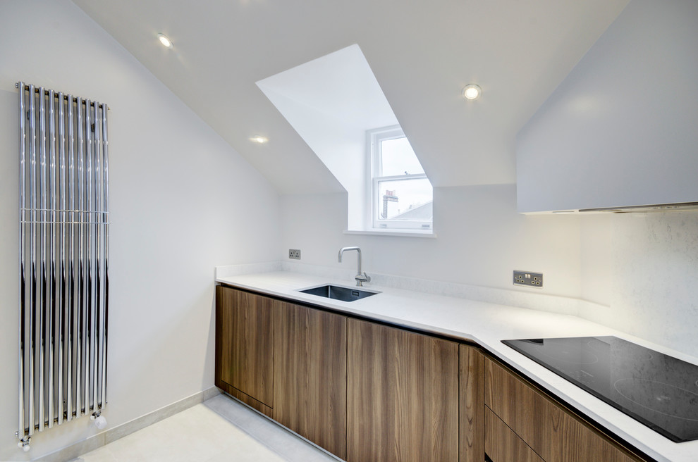 Inspiration for a medium sized contemporary u-shaped open plan kitchen in London with a built-in sink, flat-panel cabinets, medium wood cabinets, marble worktops, white splashback, marble splashback, black appliances, limestone flooring and white floors.