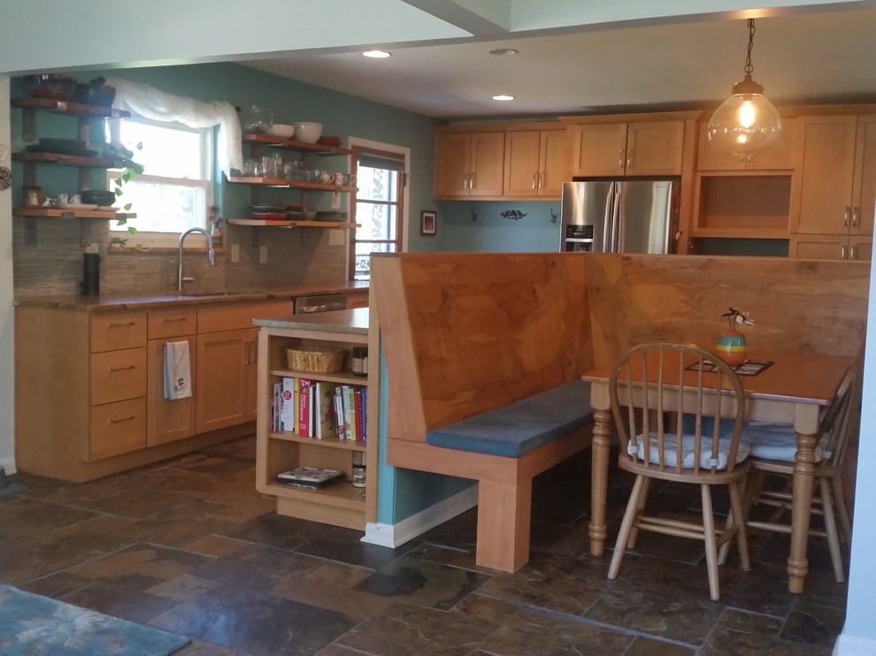 Cette photo montre une cuisine américaine rétro en L et bois clair de taille moyenne avec un évier encastré, un placard à porte shaker, un électroménager en acier inoxydable, îlot et un sol en ardoise.