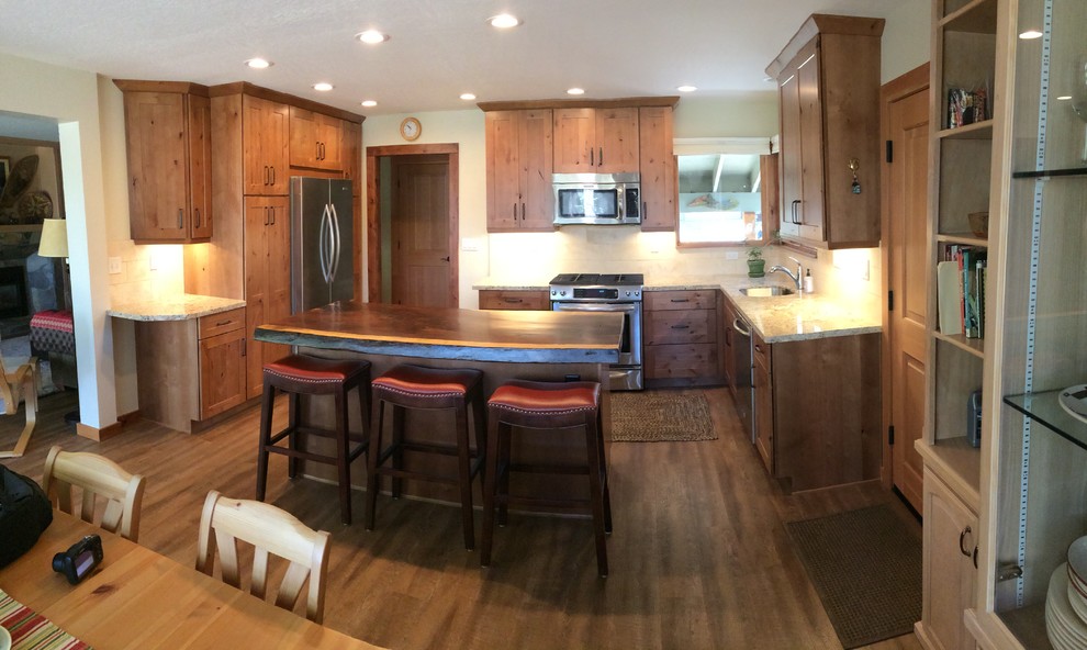 Foto på ett avskilt, litet rustikt u-kök, med en undermonterad diskho, skåp i shakerstil, skåp i slitet trä, granitbänkskiva, beige stänkskydd, stänkskydd i stenkakel, rostfria vitvaror, vinylgolv och en köksö