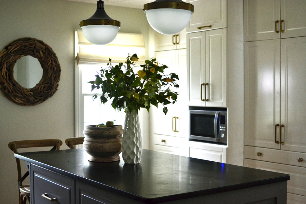 Foto på ett avskilt, mellanstort eklektiskt u-kök, med luckor med upphöjd panel, vita skåp, bänkskiva i täljsten, vitt stänkskydd, stänkskydd i marmor, rostfria vitvaror och en köksö