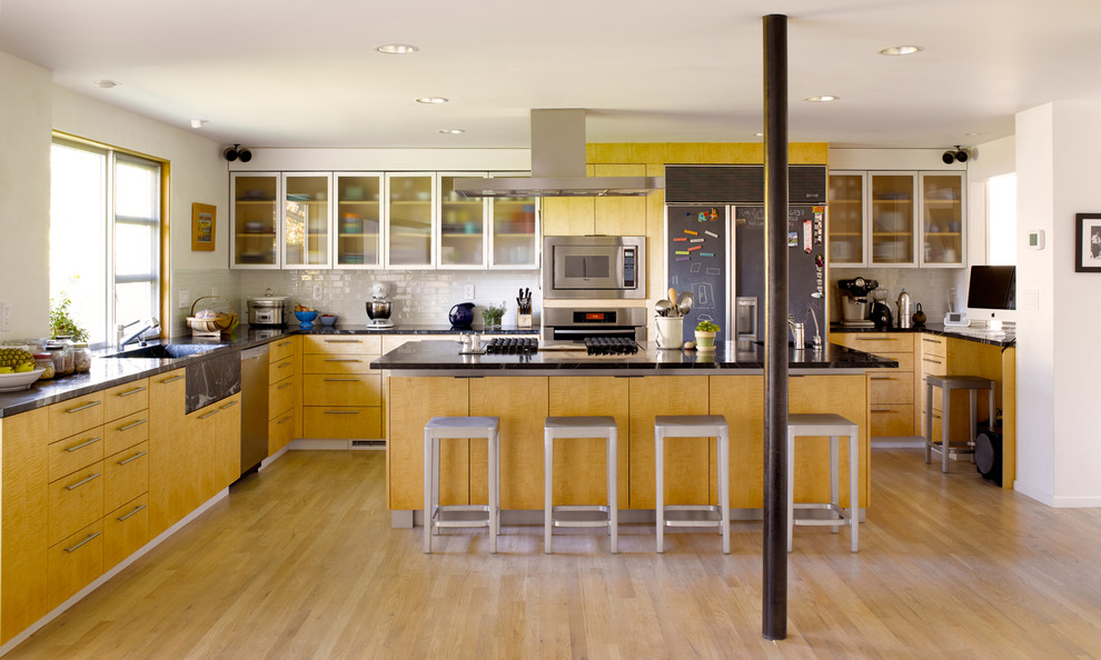 Esempio di una cucina ad U moderna con ante di vetro, ante in legno chiaro, paraspruzzi bianco, paraspruzzi con piastrelle diamantate e elettrodomestici in acciaio inossidabile