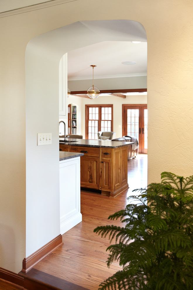Exempel på ett mellanstort klassiskt kök, med en undermonterad diskho, släta luckor, vita skåp, granitbänkskiva, grönt stänkskydd, stänkskydd i keramik, rostfria vitvaror, mellanmörkt trägolv och en köksö