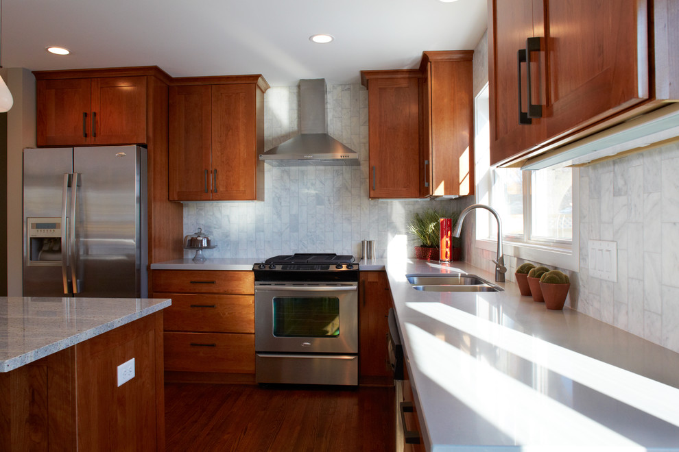 Inspiration pour une cuisine américaine design en L et bois brun avec un évier encastré, un plan de travail en quartz modifié, une crédence blanche et un électroménager en acier inoxydable.