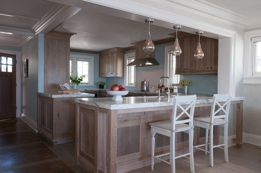 Bild på ett mellanstort maritimt kök, med en enkel diskho, skåp i shakerstil, skåp i mellenmörkt trä, marmorbänkskiva, blått stänkskydd, rostfria vitvaror, mellanmörkt trägolv och en halv köksö