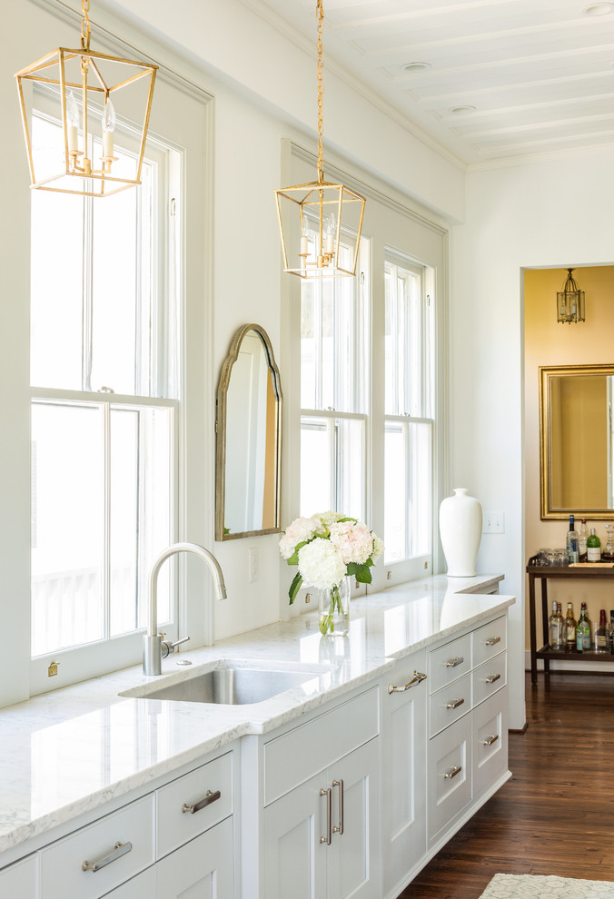 Klassische Küche mit Unterbauwaschbecken, Schrankfronten im Shaker-Stil, weißen Schränken, dunklem Holzboden und braunem Boden in Charleston