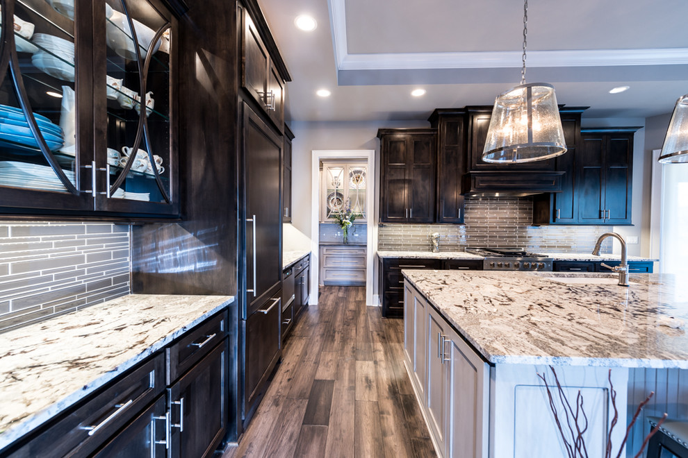 Transitional l-shaped dark wood floor open concept kitchen photo in Kansas City with an undermount sink, beaded inset cabinets, dark wood cabinets, granite countertops, brown backsplash, matchstick tile backsplash, stainless steel appliances and an island