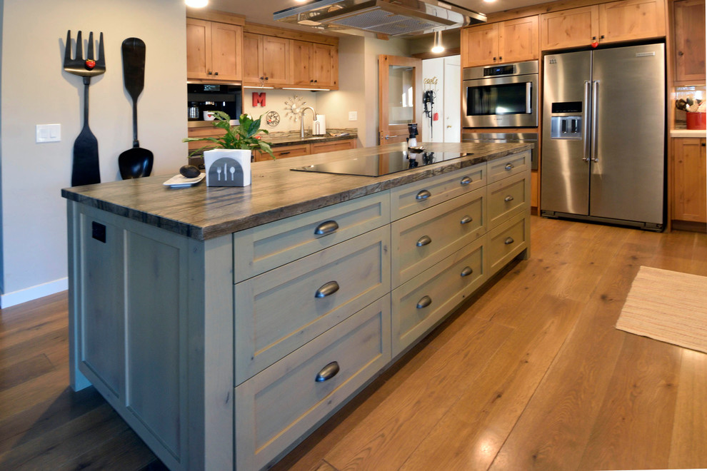 Bild på ett mellanstort amerikanskt kök, med en rustik diskho, skåp i shakerstil, skåp i ljust trä, granitbänkskiva, flerfärgad stänkskydd, stänkskydd i stickkakel, rostfria vitvaror, ljust trägolv och en köksö