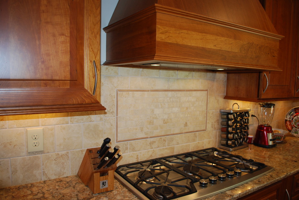 Bild på ett avskilt, stort vintage l-kök, med en undermonterad diskho, luckor med upphöjd panel, skåp i mellenmörkt trä, bänkskiva i kvarts, beige stänkskydd, stänkskydd i porslinskakel, rostfria vitvaror, mellanmörkt trägolv och en köksö