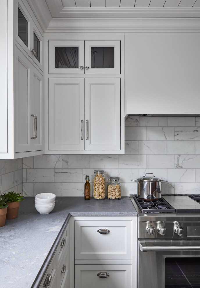 Idéer för mellanstora vintage grått l-kök, med en undermonterad diskho, luckor med profilerade fronter, vita skåp, bänkskiva i kvarts, vitt stänkskydd, stänkskydd i marmor, rostfria vitvaror, kalkstensgolv, en köksö och grått golv