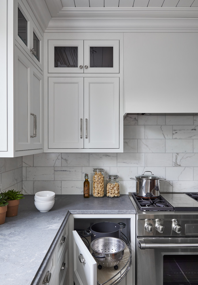 Foto på ett mellanstort vintage grå kök, med en undermonterad diskho, luckor med profilerade fronter, vita skåp, bänkskiva i kvarts, vitt stänkskydd, stänkskydd i marmor, rostfria vitvaror, kalkstensgolv, en köksö och grått golv