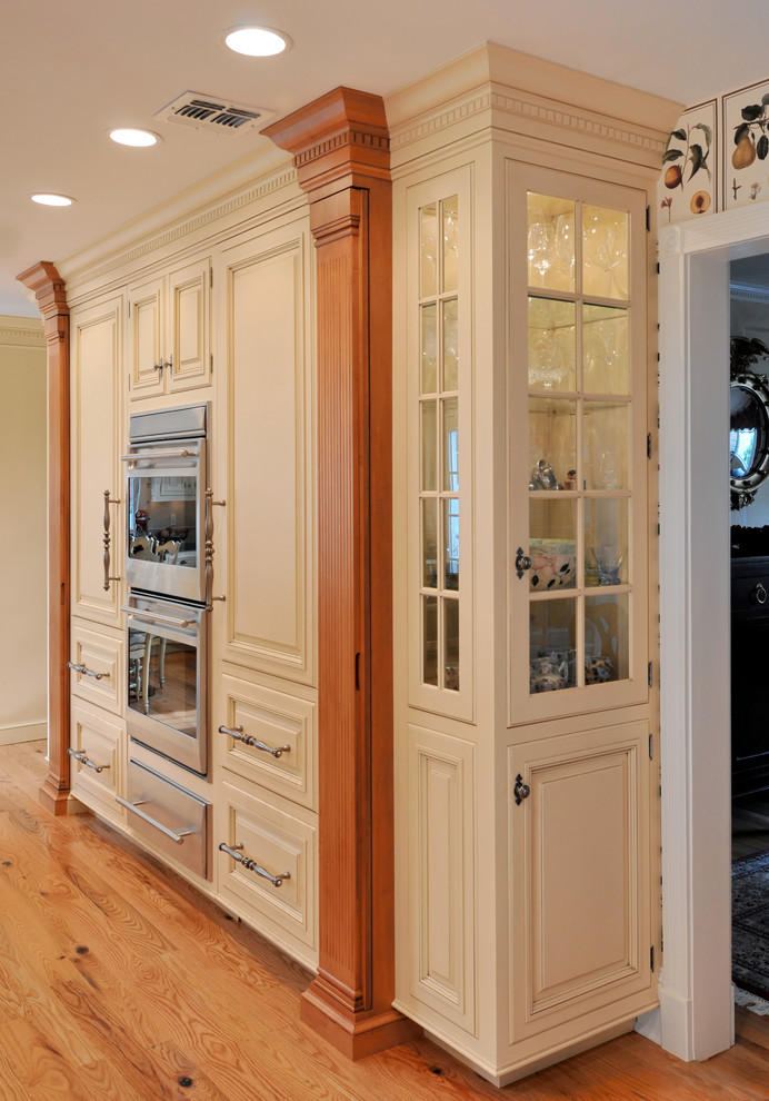 Foto de cocina comedor lineal clásica con armarios tipo vitrina, puertas de armario amarillas y suelo de madera clara
