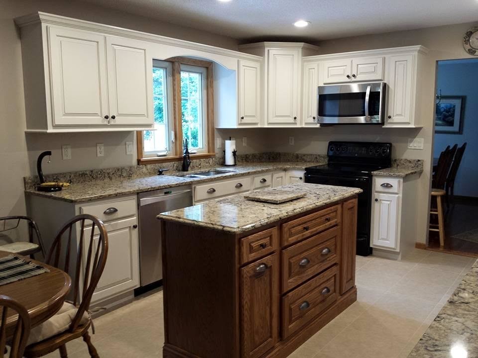 Zweizeilige Landhausstil Küche mit Doppelwaschbecken, profilierten Schrankfronten, weißen Schränken, Granit-Arbeitsplatte, Kücheninsel und schwarzen Elektrogeräten in St. Louis