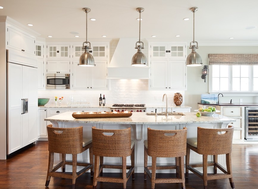Large beach style l-shaped dark wood floor and brown floor eat-in kitchen photo in New York with an island, beaded inset cabinets, white cabinets, white backsplash, subway tile backsplash, stainless steel appliances, an undermount sink and marble countertops