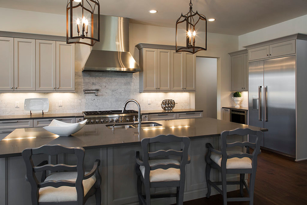Example of a large transitional l-shaped dark wood floor eat-in kitchen design in Tampa with a double-bowl sink, recessed-panel cabinets, gray cabinets, solid surface countertops, white backsplash, stone tile backsplash, stainless steel appliances and an island