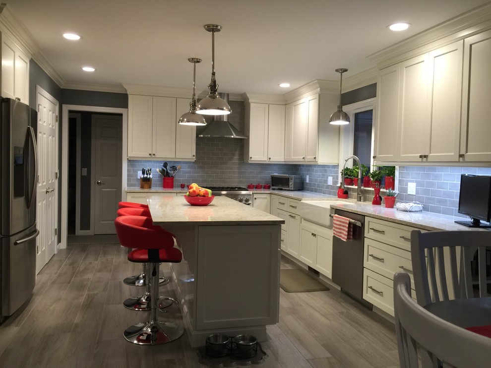 Photo of a medium sized classic l-shaped kitchen/diner in Bridgeport with a belfast sink, shaker cabinets, white cabinets, marble worktops, grey splashback, ceramic splashback, stainless steel appliances, vinyl flooring and an island.