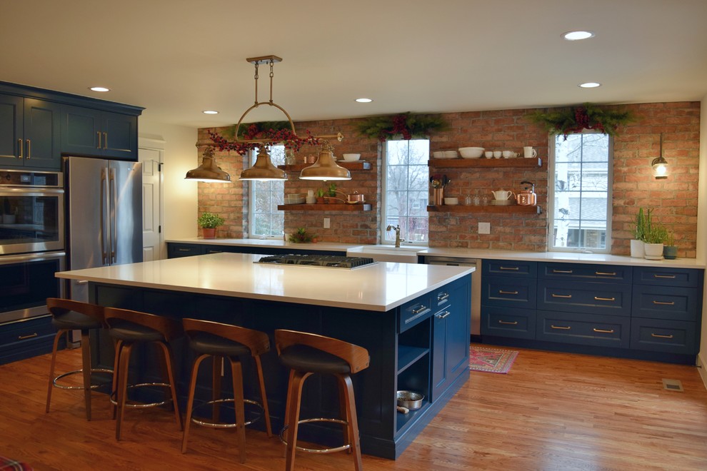 Inredning av ett klassiskt stort kök, med en rustik diskho, skåp i shakerstil, blå skåp, rostfria vitvaror och en köksö