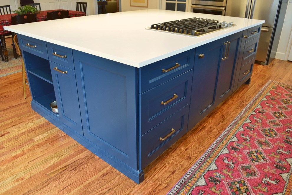 This is an example of a large traditional l-shaped kitchen/diner with a belfast sink, shaker cabinets, blue cabinets, stainless steel appliances and an island.