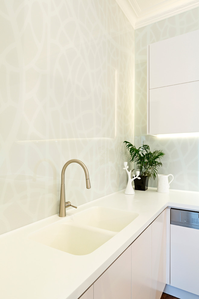 Immagine di una cucina minimal con lavello integrato, ante lisce, ante bianche, top in marmo, paraspruzzi grigio e paraspruzzi con lastra di vetro