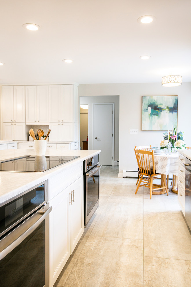 Idéer för att renovera ett mycket stort vintage vit vitt kök, med en undermonterad diskho, luckor med infälld panel, vita skåp, granitbänkskiva, vitt stänkskydd, stänkskydd i marmor, rostfria vitvaror, klinkergolv i porslin, en köksö och grått golv
