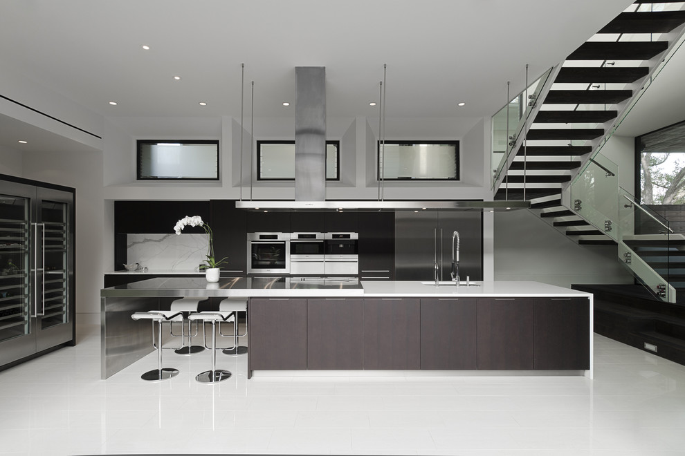 Example of a trendy galley open concept kitchen design in Houston with stainless steel appliances, an undermount sink and flat-panel cabinets