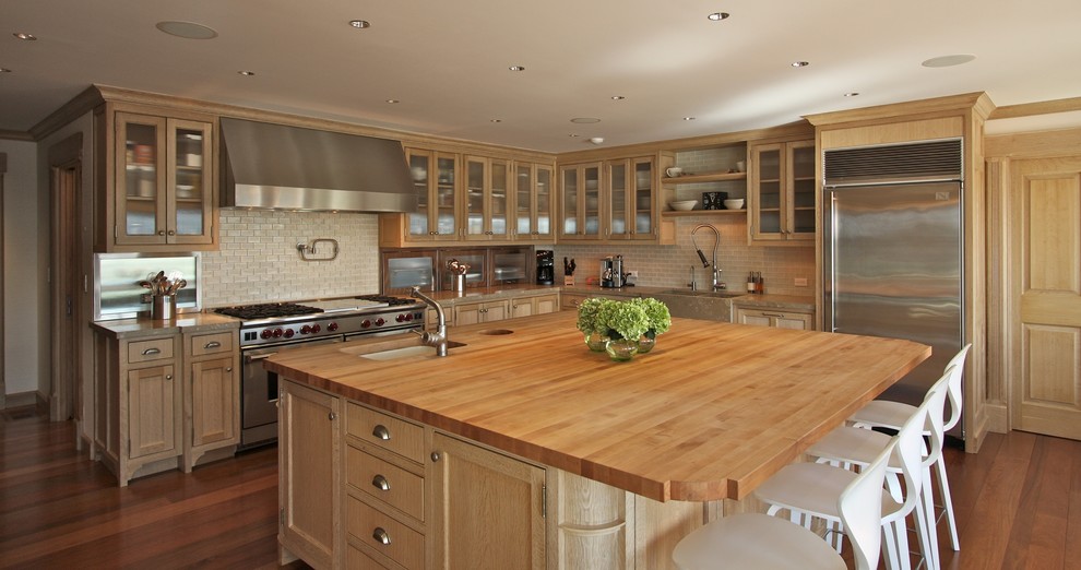 This is an example of a large traditional l-shaped kitchen/diner in New York with glass-front cabinets, light wood cabinets, marble worktops, ceramic splashback, dark hardwood flooring and an island.