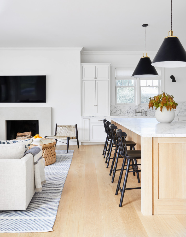 Eat-in kitchen - mid-sized coastal l-shaped light wood floor and brown floor eat-in kitchen idea in New York with a drop-in sink, beaded inset cabinets, white cabinets, marble countertops, white backsplash, marble backsplash, stainless steel appliances, an island and white countertops
