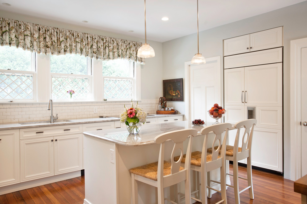 Klassische Küche mit Unterbauwaschbecken, Schrankfronten mit vertiefter Füllung, weißen Schränken, Elektrogeräten mit Frontblende und Mauersteinen in Boston