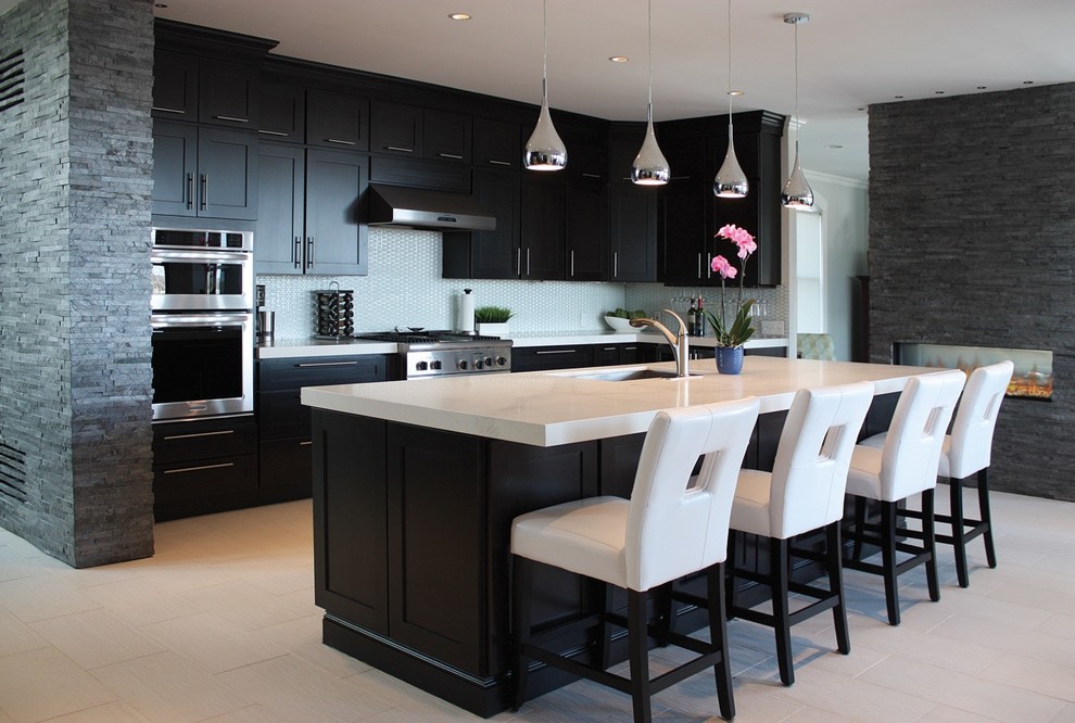 Example of a large trendy l-shaped porcelain tile and white floor enclosed kitchen design in Boston with an undermount sink, shaker cabinets, black cabinets, marble countertops, blue backsplash, stainless steel appliances, an island and white countertops
