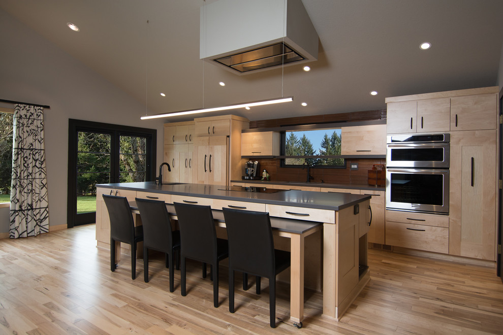 Trendy light wood floor kitchen photo in Portland with light wood cabinets, brown backsplash, stainless steel appliances and an island