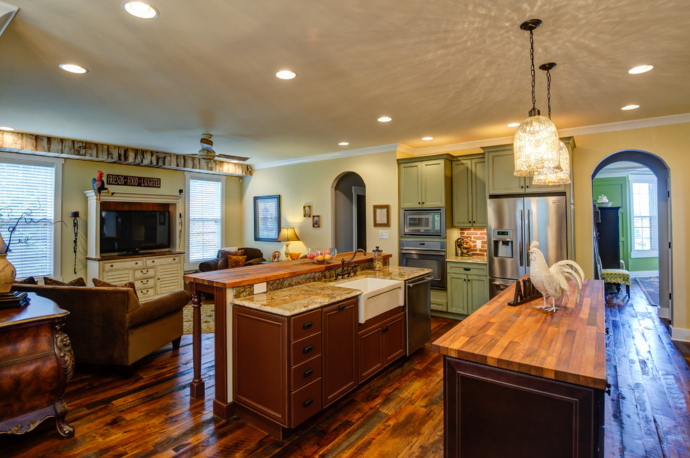 Eat-in kitchen - large country l-shaped medium tone wood floor and brown floor eat-in kitchen idea in Other with a farmhouse sink, beaded inset cabinets, green cabinets, wood countertops, red backsplash, brick backsplash, stainless steel appliances and two islands